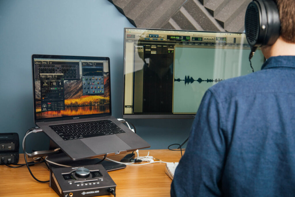 View of a man editing a podcast over his shoulder